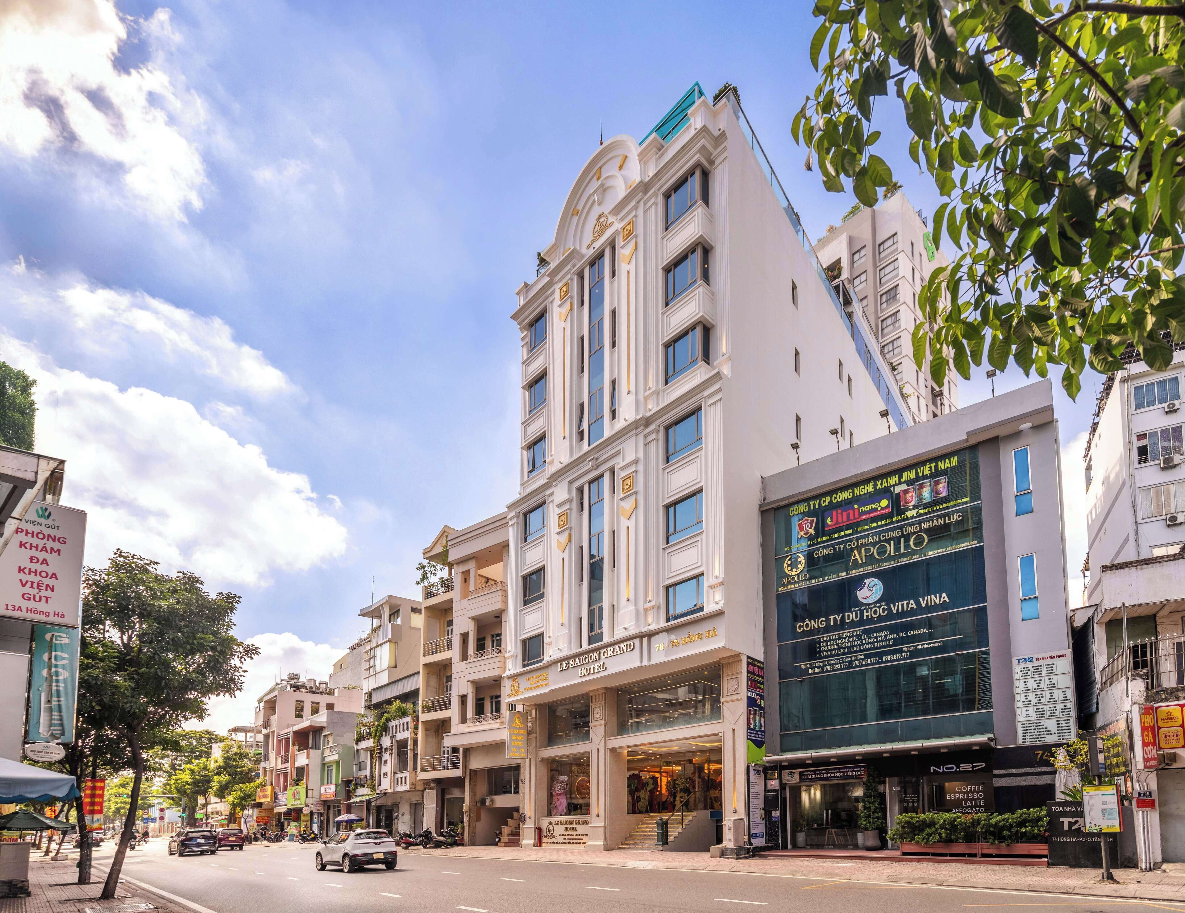 Un hotel de varios pisos con un letrero llamativo que dice 'Le Saigon Grand Hotel'.