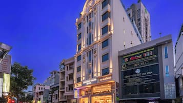 Un hôtel à étages, doté d’une entrée imposante et d’une façade bien éclairée.