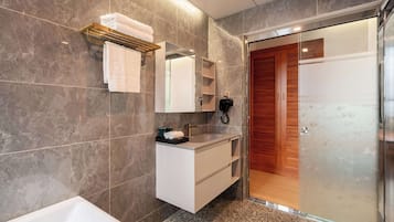 A modern bathroom with a white vanity, a large mirror, and a glass shower enclosure.
