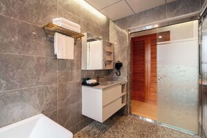 A modern bathroom with a white vanity, a large mirror, and a glass shower enclosure.