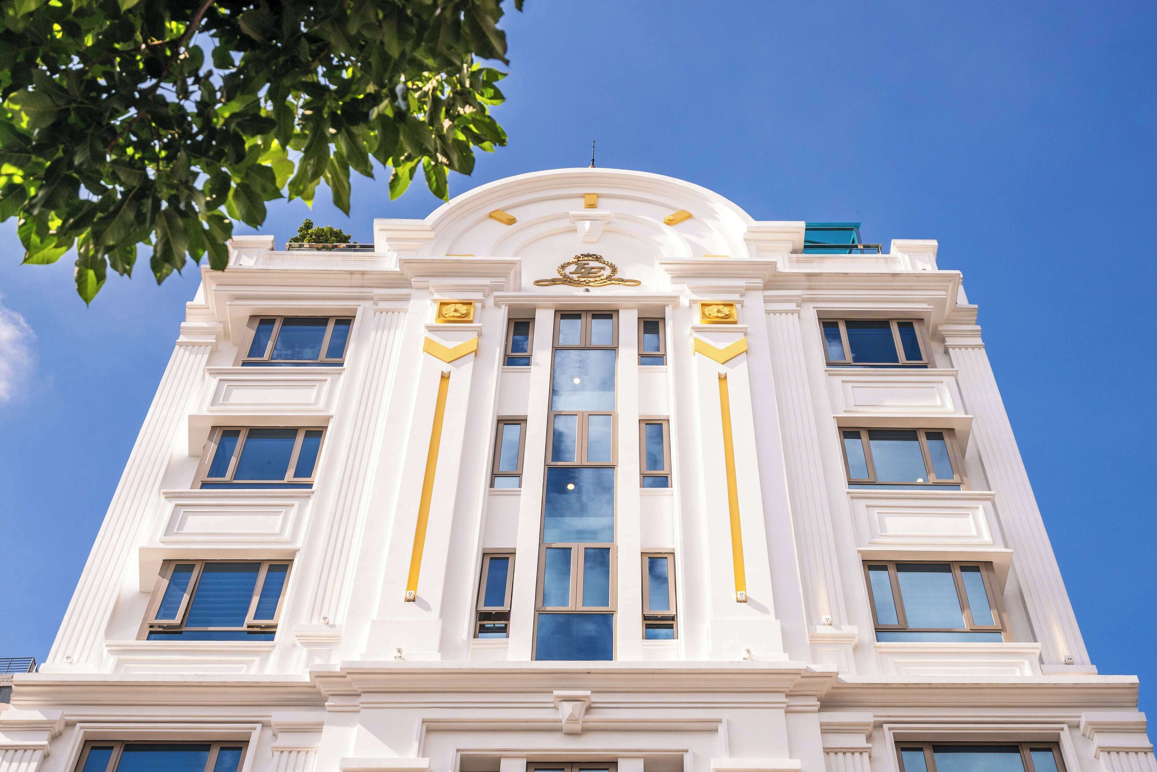 Ein mehrstöckiges Gebäude mit einer symmetrischen Fassade, großen Fenstern und dekorativen Goldakzenten.