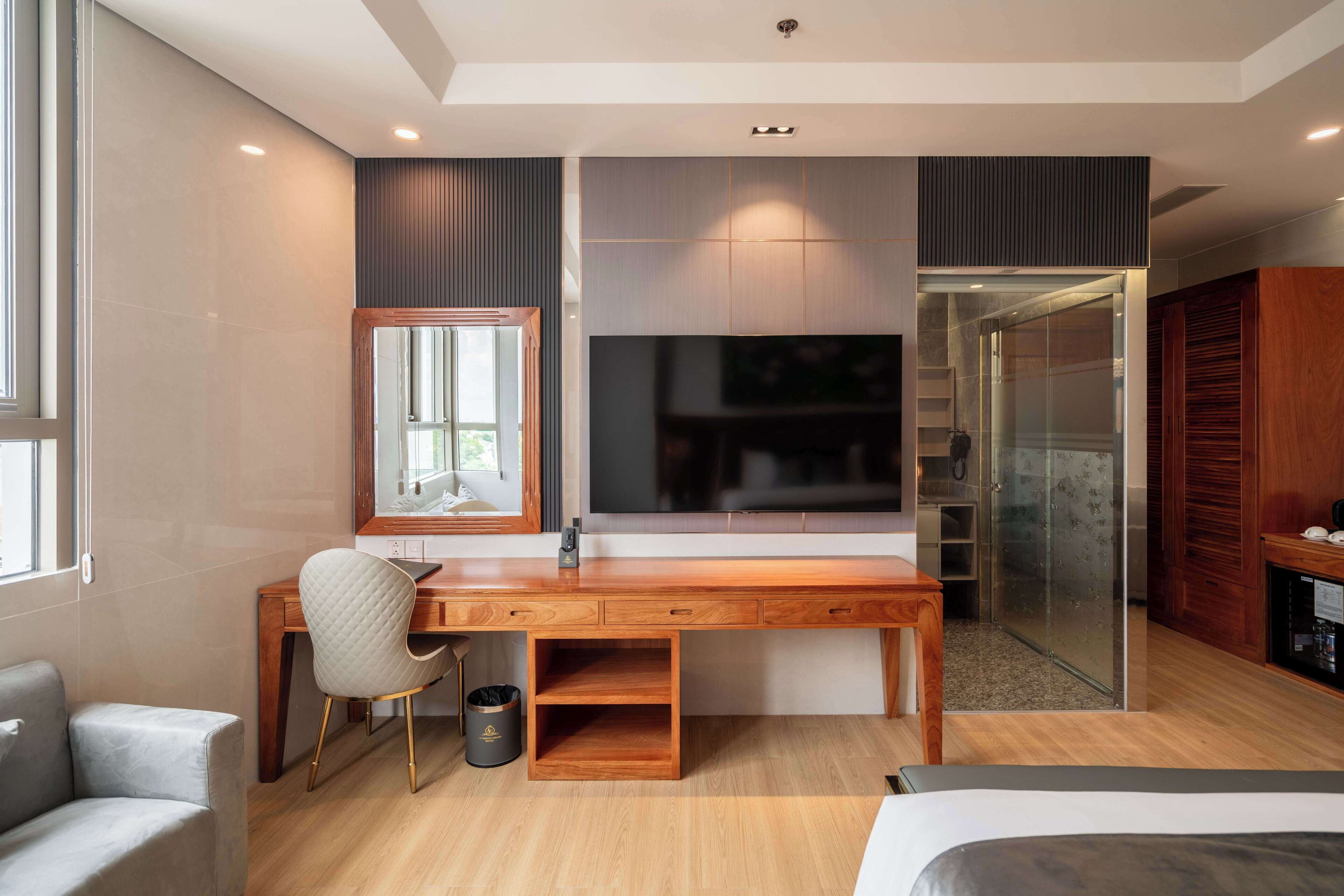 Een moderne slaapkamer met een houten bureau, een comfortabele stoel, een bed en een inloopkast.
