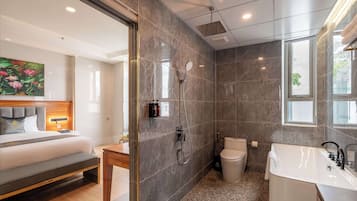 Et moderne badeværelse med bruser, toilet og badekar.