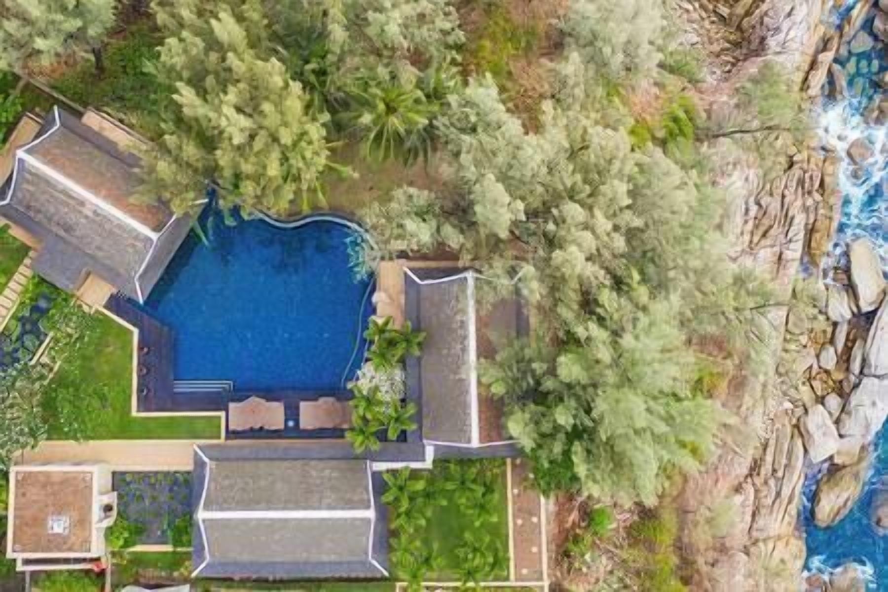 Vista aérea de una propiedad con piscina, zona de patio y vistas al océano.