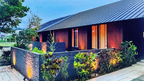 A modern house with a curved roof, a brick exterior, and a well-maintained garden. - Limited to one pair per day! The entire building is reserved for private use! A luxurious inn designed in a modern Japanese style! You can enjoy your private time in the nature of Amami Oshima with a large projector. ⭐︎ (龍郷町)