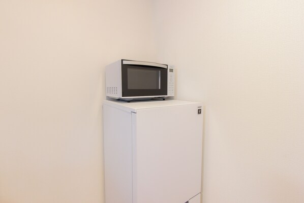 A white refrigerator with a microwave on top. - Felice Hakata (Fukuoka)