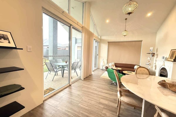Relax and unwind in a bright, modern escape. This home features a cozy living area with a plush leather sofa, a dedicated dining space for meals, and large sliding doors that open to a private patio. Perfect for your next getaway!