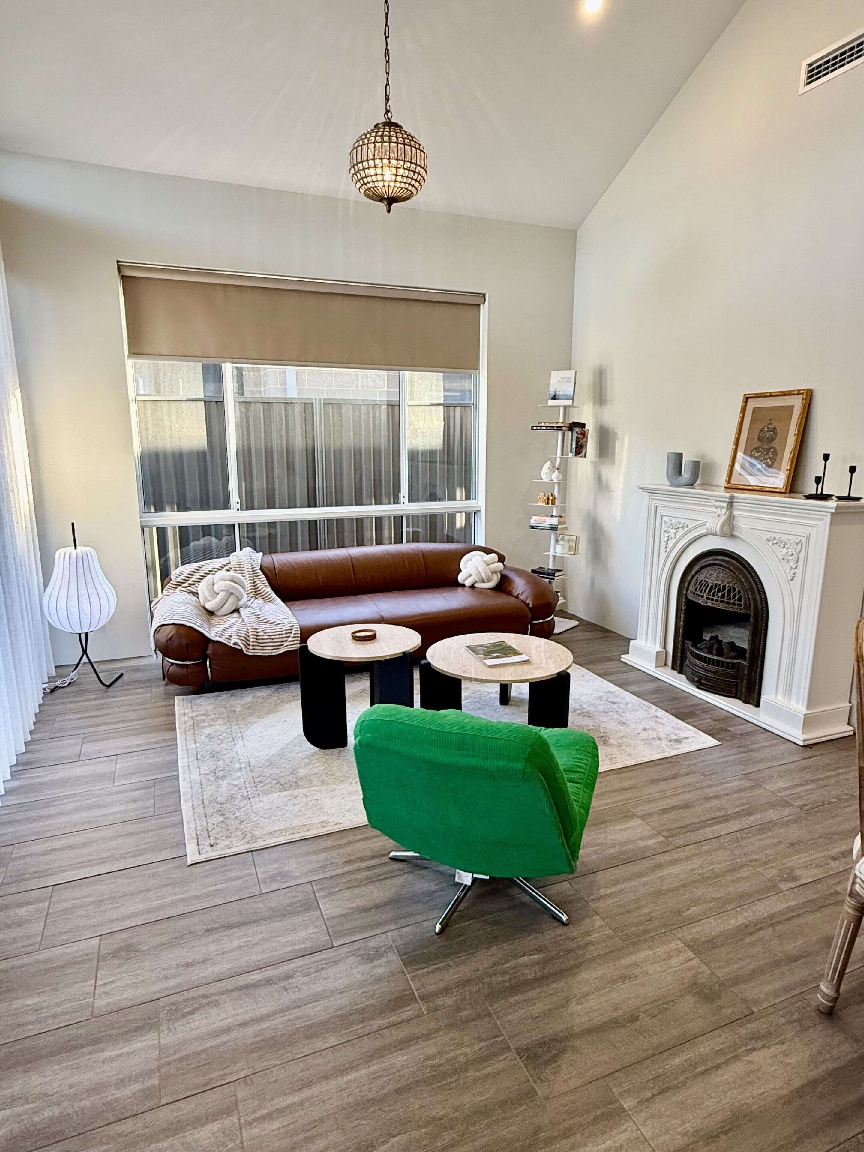 Your serene getaway awaits. Unwind in this cozy living room, complete with a comfortable leather sofa, a charming fireplace, and plenty of natural light. It's the perfect place to relax and feel at home.