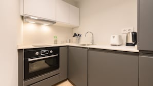 A modern kitchen with a built-in oven, a coffee maker, and a sink.