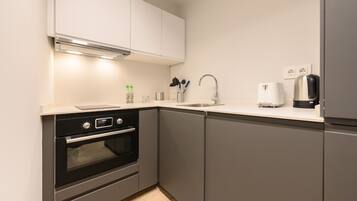 Een koelkast, een oven, een koffiezetapparaat/waterkoker, een waterkoker