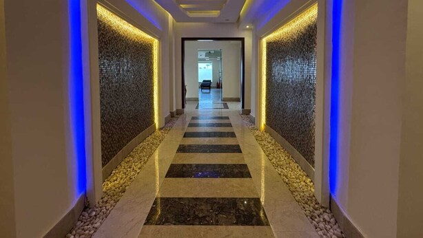A modern hotel corridor with a central walkway, decorative lighting, and textured walls. - Rosetta Hotel & SPA (Sharm El Sheikh)