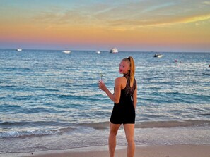 A person standing on a beach with the ocean and boats in the background. - Rosetta Hotel & SPA (Sharm El Sheikh)