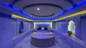 A modern spa with a central circular hot tub, surrounded by seating areas and decorative elements. - Rosetta Hotel & SPA (Sharm El Sheikh)