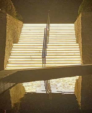 A set of stairs leading up to a brightly lit area with a reflective pool at the bottom. - Rosetta Hotel & SPA (Sharm El Sheikh)