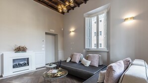 Una sala de estar moderna con chimenea, sofá y una mesa de centro redonda.