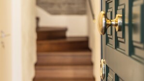 Una escalera que lleva a un rellano con una puerta.