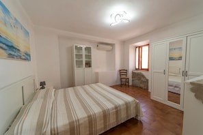 A bedroom with a bed, wardrobe, and a small seating area.