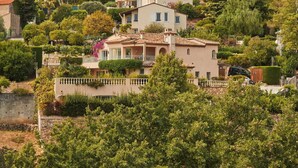 A hillside villa with a terracotta-tiled roof, surrounded by lush greenery and other residential buildings. - Villa Casa Rosetta A/C avec Piscine & Jacuzzi  -Vallauris (Vallauris)