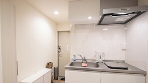 A compact kitchen with a sink, kettle, and a scale on the countertop. - HOTEL FAMILIA Hakata East (Fukuoka)