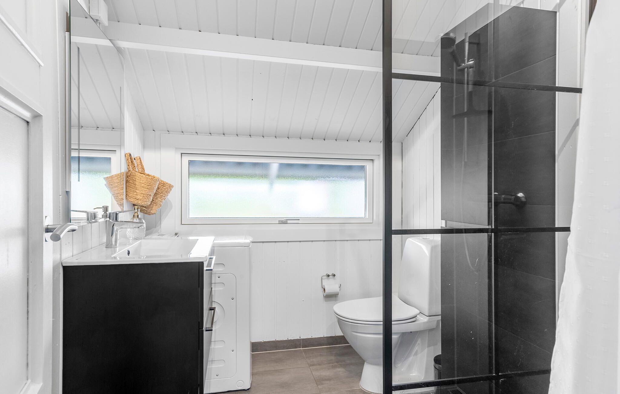 Une salle de bain moderne avec un meuble-lavabo blanc, des toilettes et un espace douche.