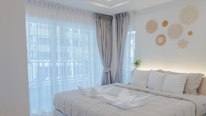 Una cama bien tendida con cubrecama acolchado, una mesita de noche con lámpara y una pared con motivos circulares decorativos.