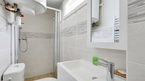 Une salle de bain moderne équipée d’une douche, de toilettes et d’un lavabo.
