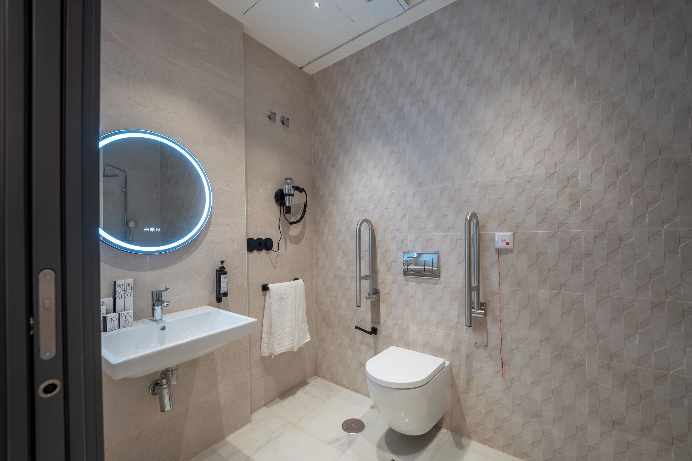 A modern bathroom with a white sink, a toilet, and a shower.