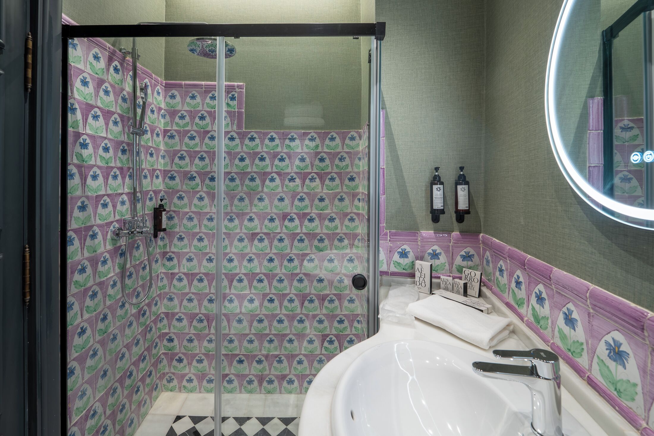 A bathroom with a shower area, a sink, and a mirror.