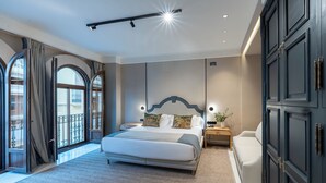 Een moderne slaapkamer met een groot bed, een nachtkastje, een bank en uitzicht op de omgeving.