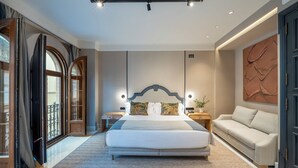 Een moderne hotelkamer met een groot bed, een bank en een decoratieve wand.