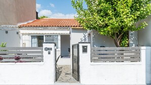 A white building with a tiled roof, a gated entrance, and a tree in front. - Country House 'Azure Nest' with Private Terrace, Wi-Fi, and Air Conditioning (Nea Peramos)