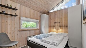 Makuuhuoneessa on sänky, tuoli, ikkuna ja vaatekaappi.