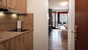 A modern kitchen with wooden cabinets and a built-in stove. - Quartier 7 apartment in a quiet location and access to the sea time (Büsum)