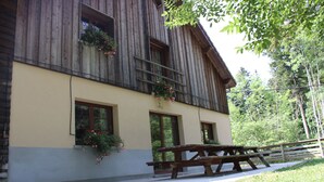 A wooden building with a picnic table in front. - Gîte l'Essentiel, farmhouse group accommodation with spa and sauna, playground (Arc-sous-Cicon)