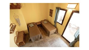 A small room with two single beds, a small table, a chair, and a macrame wall hanging. - Awesome apartment in Briatico with house sea view (Briatico)