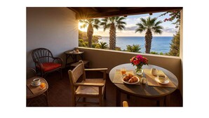 A cozy outdoor seating area with wicker chairs and a table set for breakfast, overlooking a scenic ocean view. - 2 bedroom nice apartment in Briatico (Briatico)