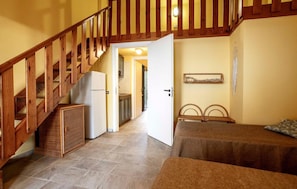 A staircase leading to a bedroom with a bed, a nightstand, and a small table.
