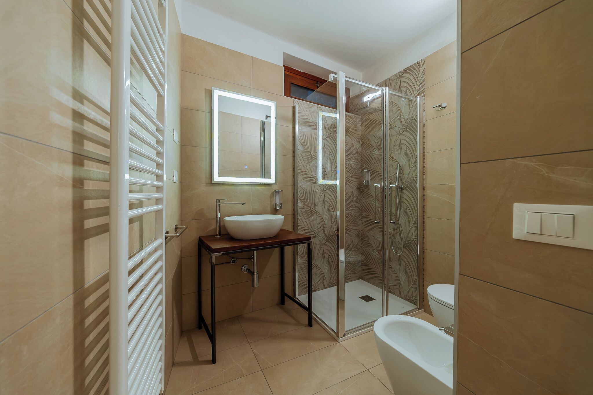 A modern bathroom with a glass shower enclosure, a vanity with a sink, and a toilet.