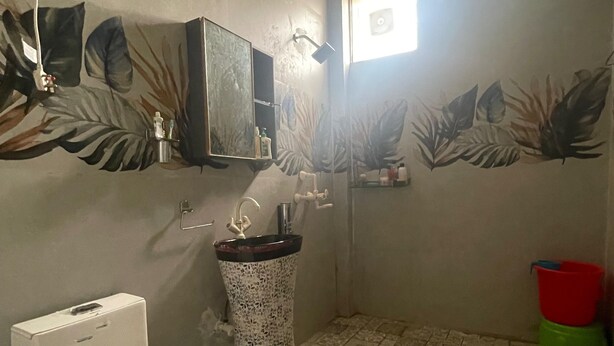 A bathroom with a toilet, sink, and shower. - Geeta Enterprises (Mathura)