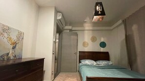 Ein Schlafzimmer mit einem Bett, einem Schminktisch und einem Bild an der Wand.