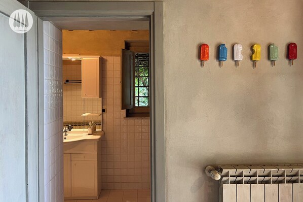A modern kitchen with white cabinets, a window with a view, and a radiator.