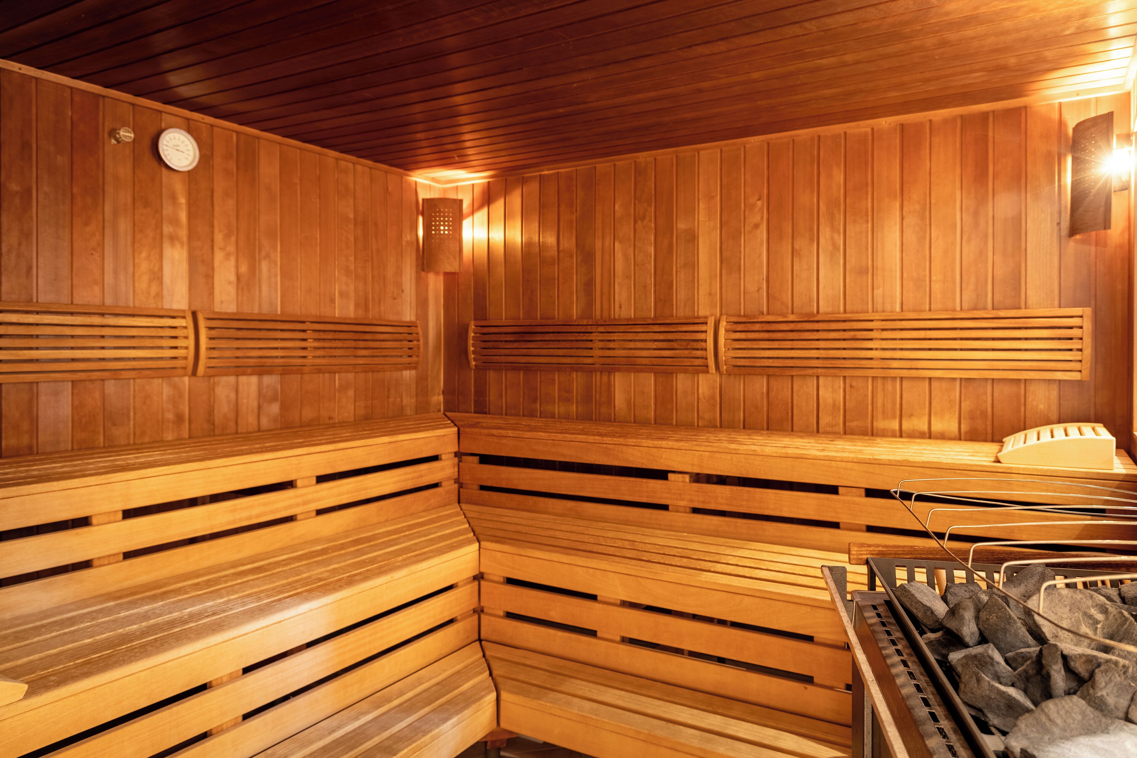 A sauna with wooden benches and a stone heating element.