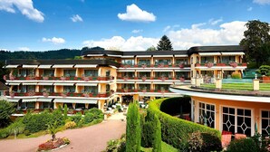 A multi-story hotel with balconies, a garden, and a pool area. - Relais & Châteaux Hotel Schwarzmatt (Badenweiler)