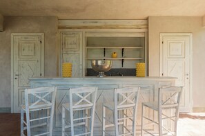 A kitchen with a central island, bar stools, and a large bowl.