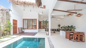 A modern interior with a pool, wooden furniture, and a ceiling fan.