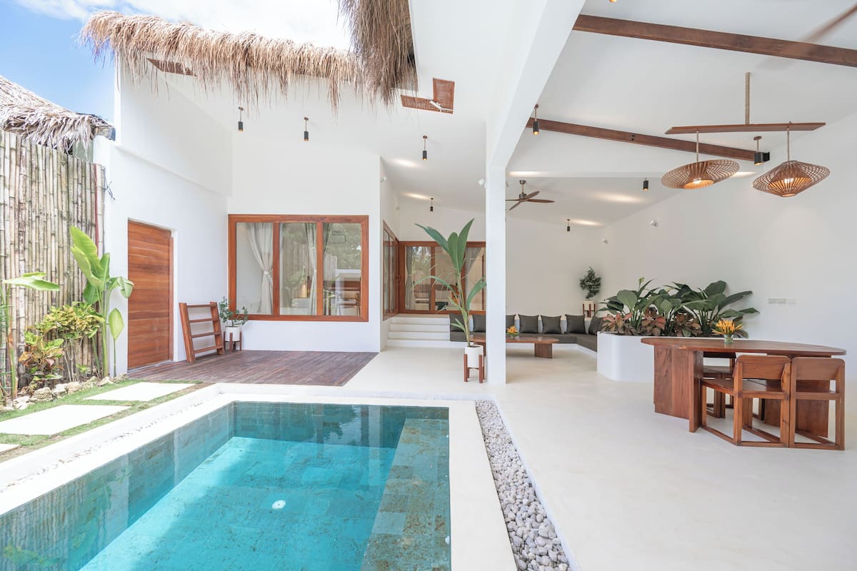 A modern interior with a pool, wooden furniture, and a ceiling fan.