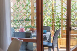 An outdoor patio with wicker furniture, a table with a blue bowl, and potted plants. - SONJA'S HOUSE (Viterbo)