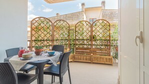 A patio with a table set for dining, a wooden bench, and a lattice fence with greenery. - HOUSE OF SONJA (Viterbo)