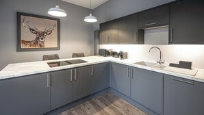 Una cucina moderna con mobili grigi, un piano di lavoro in marmo e un grande quadro raffigurante un cervo.