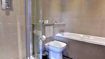 Un baño moderno con cabina de ducha de vidrio, inodoro y bañera.